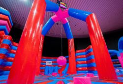 Obstáculo Swing Him Off en parque hinchable – juego hinchable rojo y azul con una gran bola oscilante para derribar a los oponentes