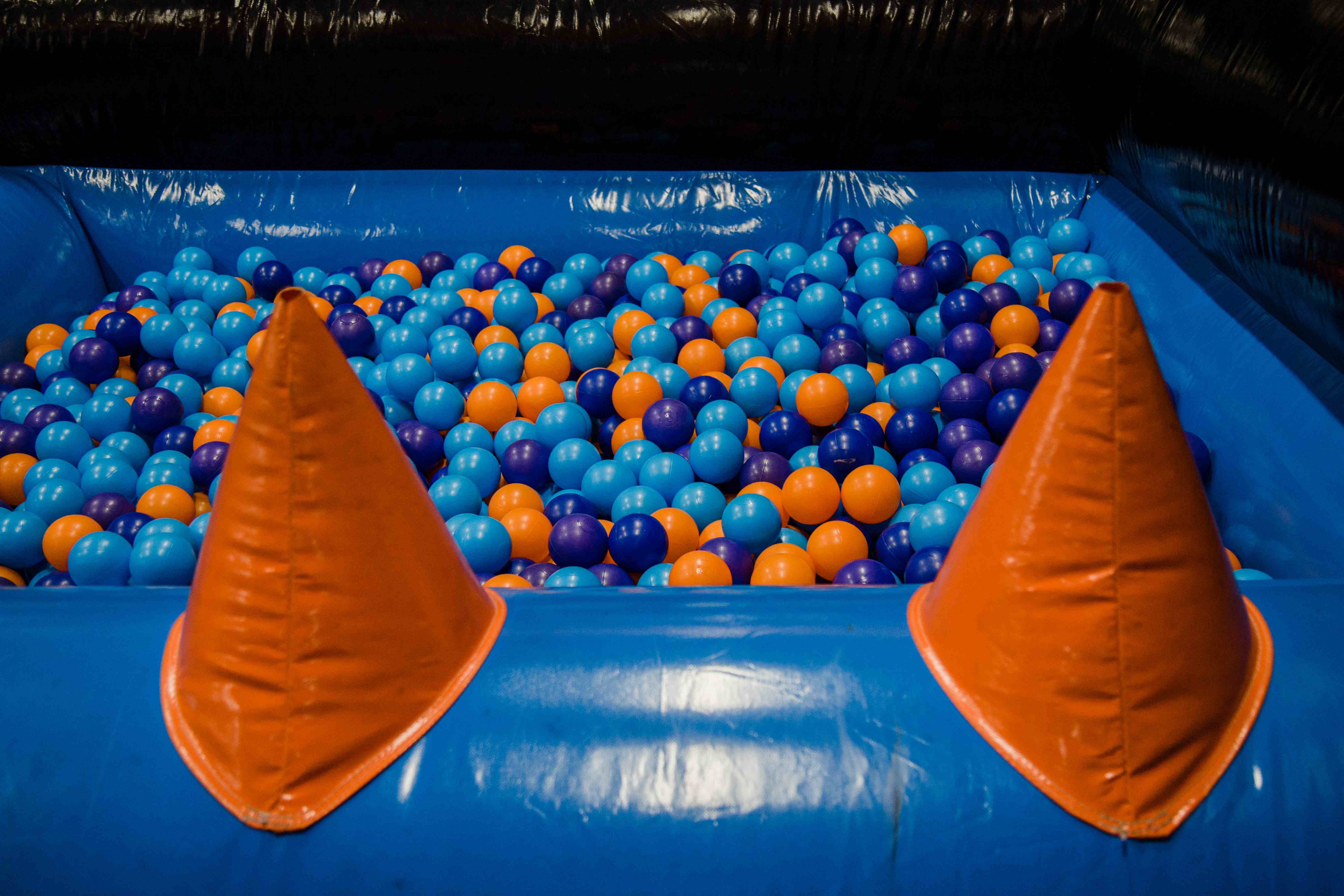 Ball pool in inflatable park – blue, orange and purple play balls in an inflatable ball pit