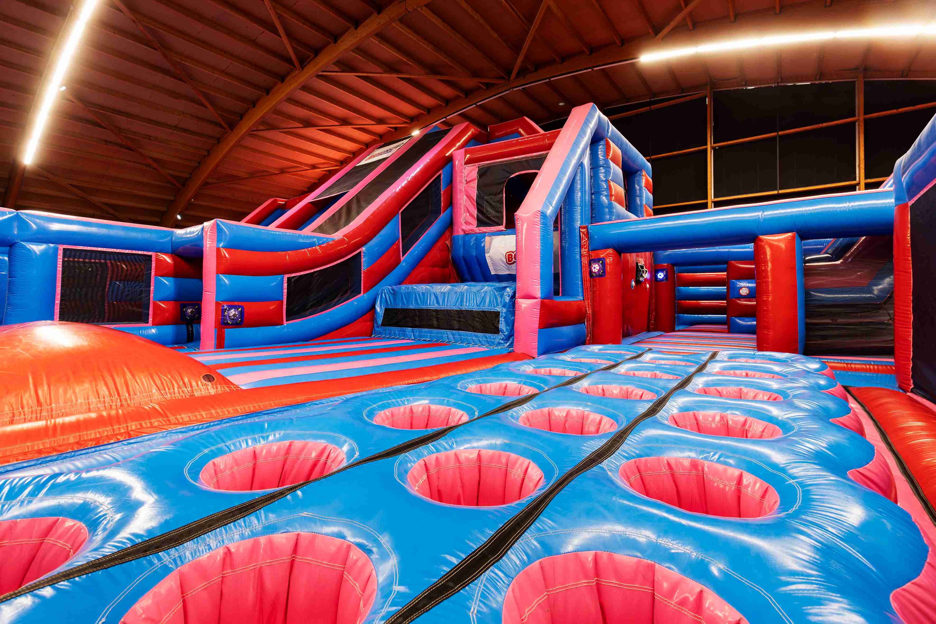 Tire Field obstacle in indoor inflatable park – blue and red inflatable course element for climbing, jumping, and running