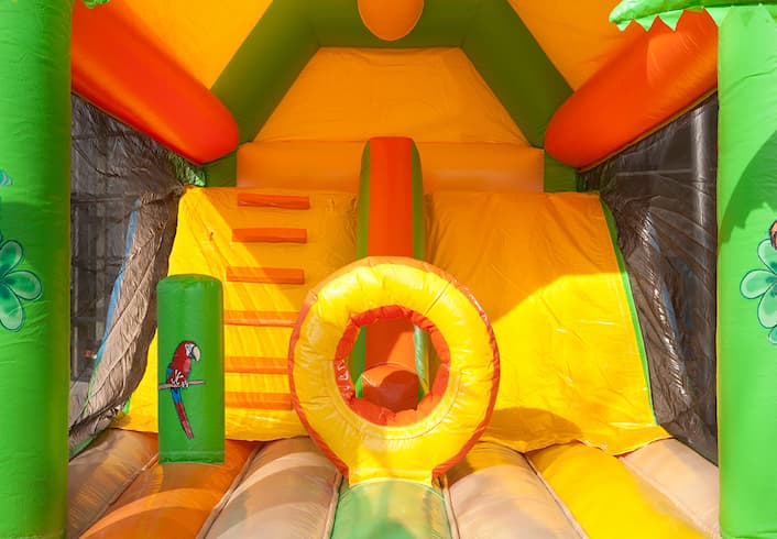 Opblaasbaar overdekt multiplay combo springkasteel met glijbaan en glij en klim mat kopen in thema jungle voor kinderen
