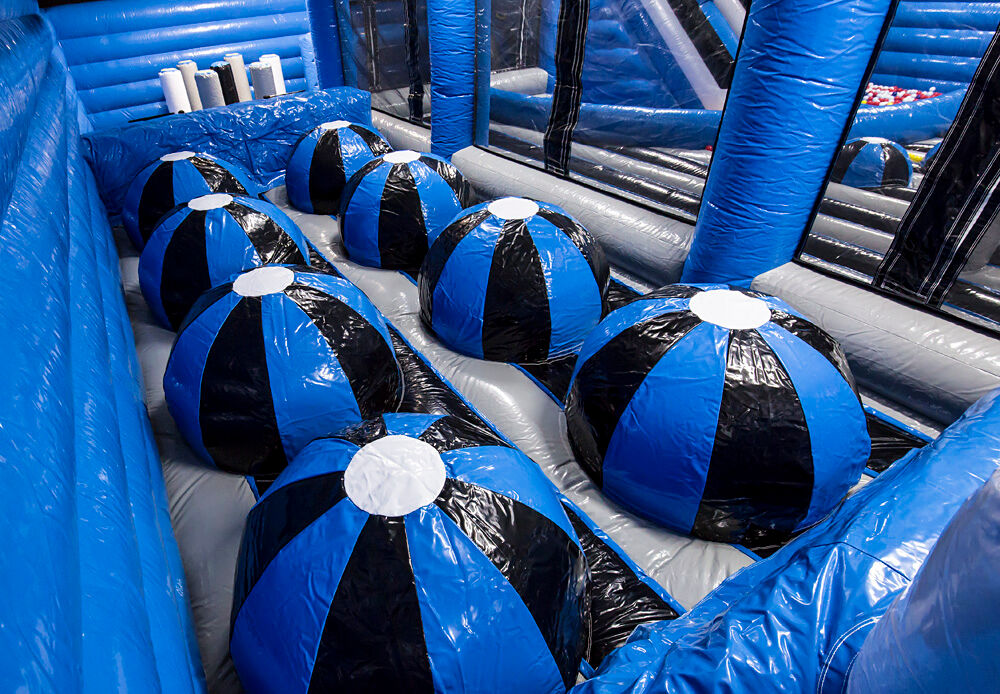 Jumping Balls obstacle in inflatable park – blue and black inflatable balls for balancing, jumping, and climbing